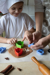 Mom and daughter make gingerbread cookies at home and have fun. household, communication, cooking.