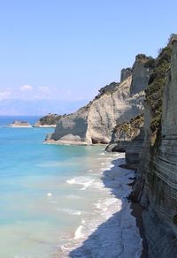 Scenic view of sea and cliff against sky
