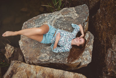 High angle view of woman lying on rock