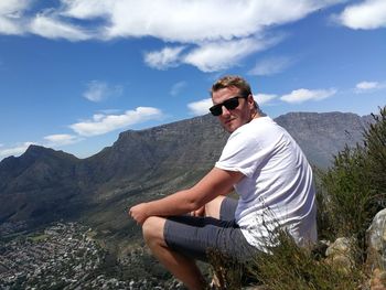 Portrait of man sitting against mountains