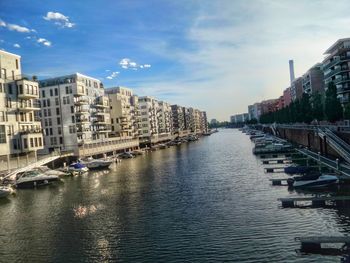 River amidst buildings in city against sky