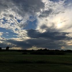 Scenic view of grassy field against cloudy sky