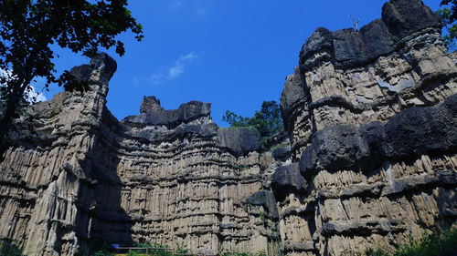 Low angle view of rock formation against sky