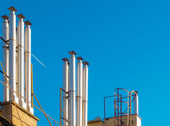 Low angle view of bird perching against blue sky