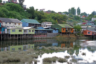 Houses by lake and buildings in town