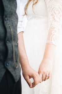 Midsection of couple holding hands