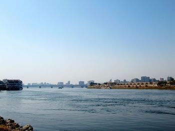 Scenic view of sea by buildings against clear sky