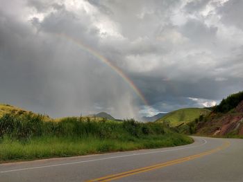 Scenic view of rainbow over road against sky