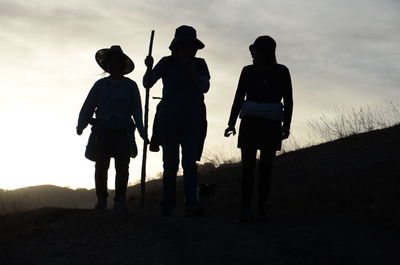 Silhouette of women walking on field