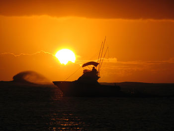 Silhouette sailboat in sea against sky during sunset