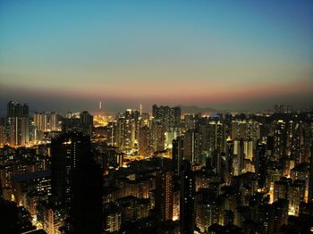 Illuminated cityscape against sky at night