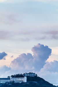 Buildings by sea against sky at sunset