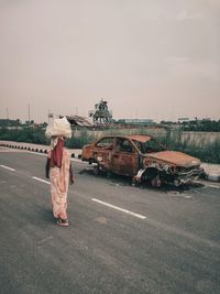 Rear view of woman walking on road against sky