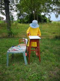 Man sitting on chair in field