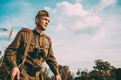 Low angle view of man looking away against sky