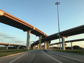 Low angle view of bridges over road against blue sky during sunset