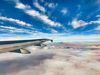 Airplane flying over clouds against blue sky