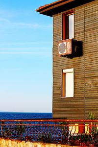 Exterior of house by sea against sky