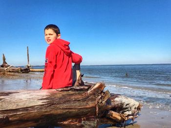 Full length of boy on beach against clear sky