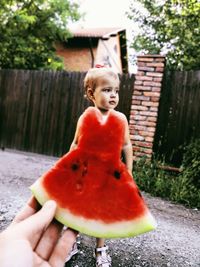 Midsection of woman holding red fruit