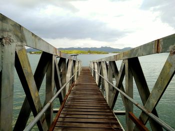 Pier over lake against sky