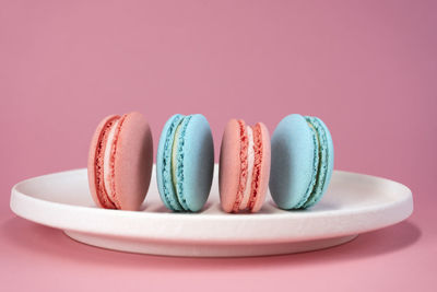 Delicious colorful french cookies macaroons on pink background. a great gift idea for 8 march