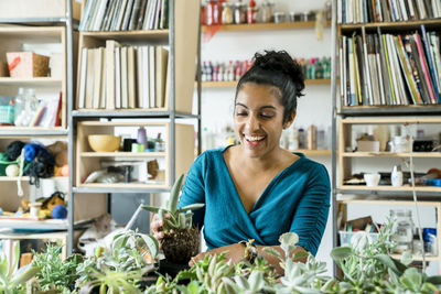 Happy businesswoman holding succulent plant in office