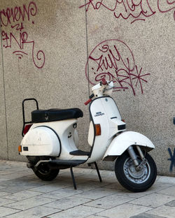 Motor scooter on street against wall
