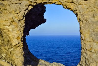 Close-up of rock formation in sea against sky