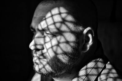 Sunlight falling on thoughtful man in darkroom