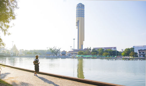 Man standing by river against sky