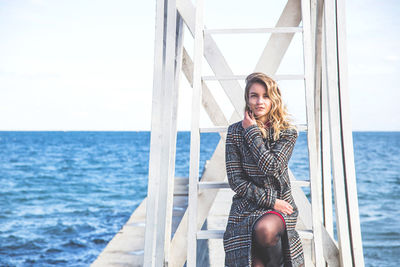 Portrait of smiling young woman against sea