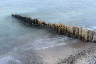 High angle view of wooden groyne at beach