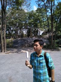 Young man eating ice cream while standing outdoors