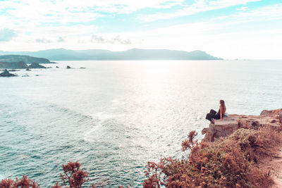 Rear view of woman looking at sea against sky