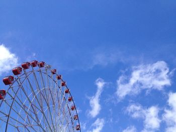 Low angle view of ferris wheel against cloudy sky