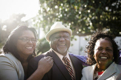 Portrait of happy parents with daughter standing at park