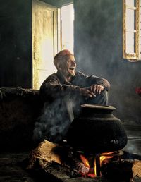 Man sitting on barbecue grill