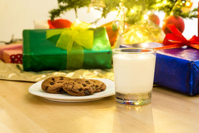 Close-up of cookies in plate by drink on table during christmas