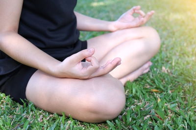 Low section of woman sitting on grass