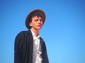 Mid adult man against clear blue sky