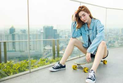 Young woman smiling while sitting in city