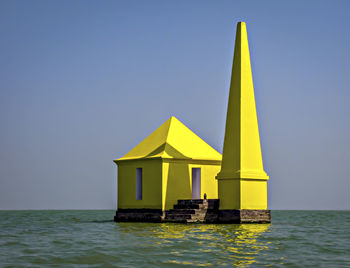 Bright yellow colored old light house also known as breakfast point in chilka lake, odisha.