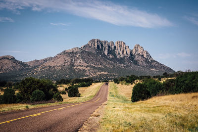 Road by mountain against sky