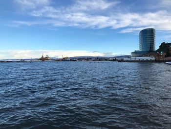 View of buildings in sea against cloudy sky