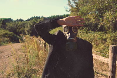 Rear view of woman photographing while standing on field