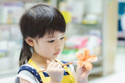 Close-up portrait of a girl holding flower