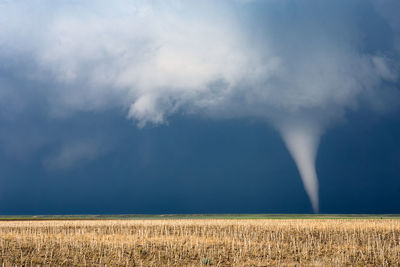 Scenic view of tornado against storm clouds