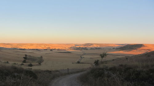 Scenic view of landscape against clear sky during sunset