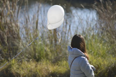 Rear view of girl standing at balloon